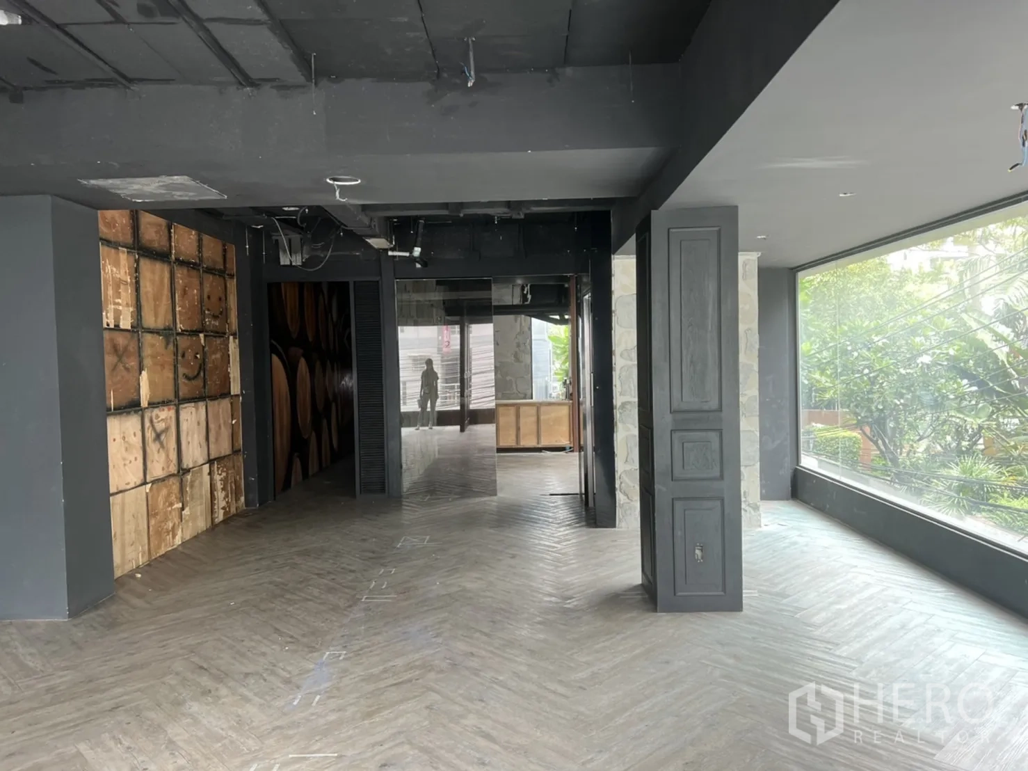 零售空间 出租在Khlong Toei, Bangkok - 开放式零售层，落地橱窗、深色天花与装饰墙板。