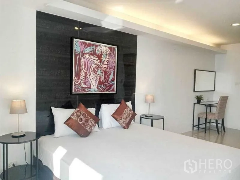 คอนโด ให้เช่าในKhlong Toei, Bangkok - ห้องนอนพร้อมเตียงใหญ่ ผนังตกแต่งภาพศิลป์ โต๊ะทำงานและโต๊ะข้าง แสงธรรมชาติ