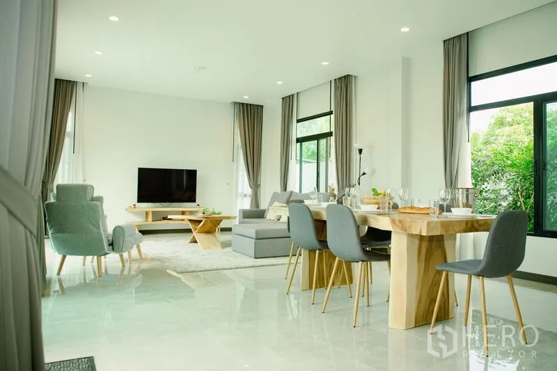 บ้าน ขายในPhra Pradaeng, Samut Prakan - ห้องนั่งเล่นและทานอาหารโอเพ่นแปลน พร้อมทีวี โซฟาสีเทา และหน้าต่างบานใหญ่