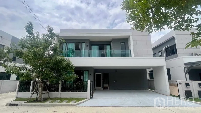 Detached House for rent in Bang Phli, Samut Prakan - Front exterior view of the contemporary house with driveway and shade trees