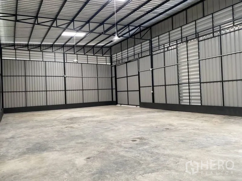 คลังสินค้า ให้เช่าในLat Phrao, Bangkok - มุมมองภายในโกดังที่มีบานระบายอากาศและท่อเดินสายไฟ.