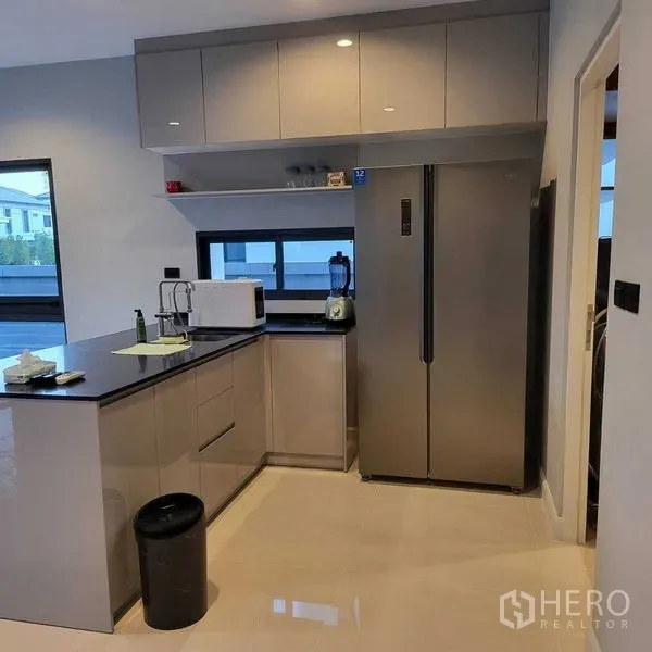 Detached House for rent in Mueang Pathum Thani, Pathum Thani - Bright L-shaped western kitchen with glossy cabinets and large fridge