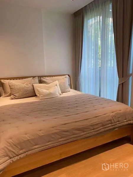 公寓 出租在Watthana, Bangkok - 采光良好的卧室，木框大床与转角落地窗