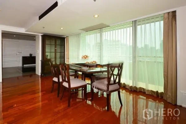 อพาร์ทเมนท์ ให้เช่าในKhlong Toei, Bangkok - มุมรับประทานอาหารข้างหน้าต่างกระจกเต็มบาน เห็นวิวเมือง พร้อมตู้โชว์กระจกบนพื้นไม้