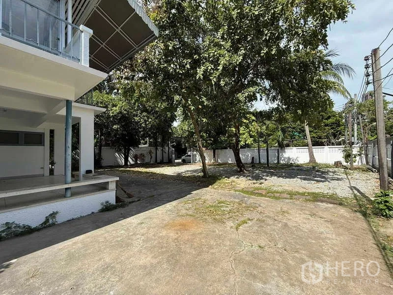 独立式住宅 出租在Watthana, Bangkok - 房屋一侧的大庭院，绿树成荫并有开阔空地。