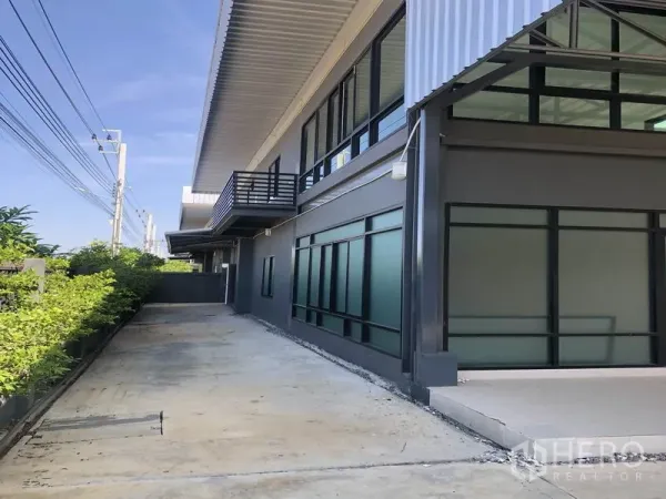 工厂 出租或出售在Bang Bo, Samut Prakan - 建筑侧边通道，带落地玻璃办公室与阳台，深檐遮阳。