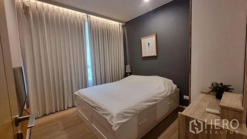 คอนโด ให้เช่าในWatthana, Bangkok - ห้องนอนที่สองอบอุ่น มีเตียงคู่ ผนังเน้นสีเข้ม ผ้าม่านทึบ และโต๊ะลิ้นชัก