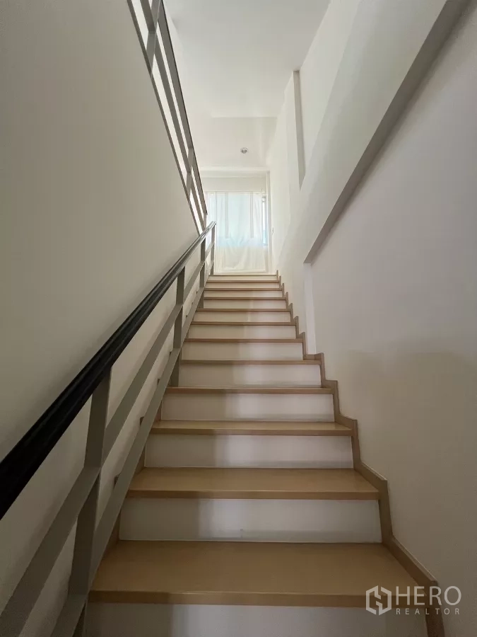 Townhouse for rent in Suan Luang, Bangkok - Stairwell filled with natural light leading to the upper floor.