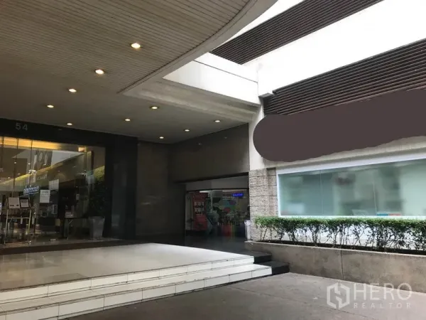 พื้นที่ขายปลีก ให้เช่าในWatthana, Bangkok - โถงทางเข้าอาคารแบบมีหลังคา ไฟดาวน์ไลต์ ติดกับหน้าร้านกระจกยาว มองเห็นชัด.