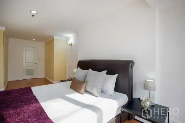 公寓 出租在Khlong Toei, Bangkok - 宽敞主卧，软包床头、床头柜与充足衣柜收纳。