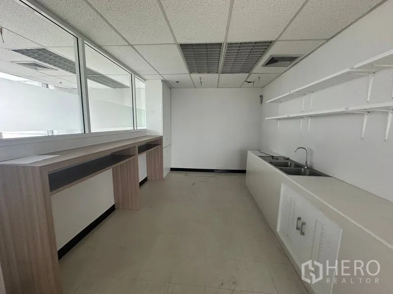 สำนักงาน ให้เช่า - มุมมองอีกด้านของครัวแพนทรี พร้อมอ่างล้างจานคู่ เคาน์เตอร์ยาว และชั้นวางผนัง