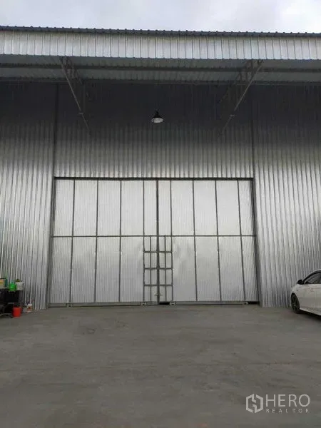 Warehouse for rent in Nong Suea, Pathum Thani - Steel-clad warehouse facade with large sliding doors and a wide concrete apron.