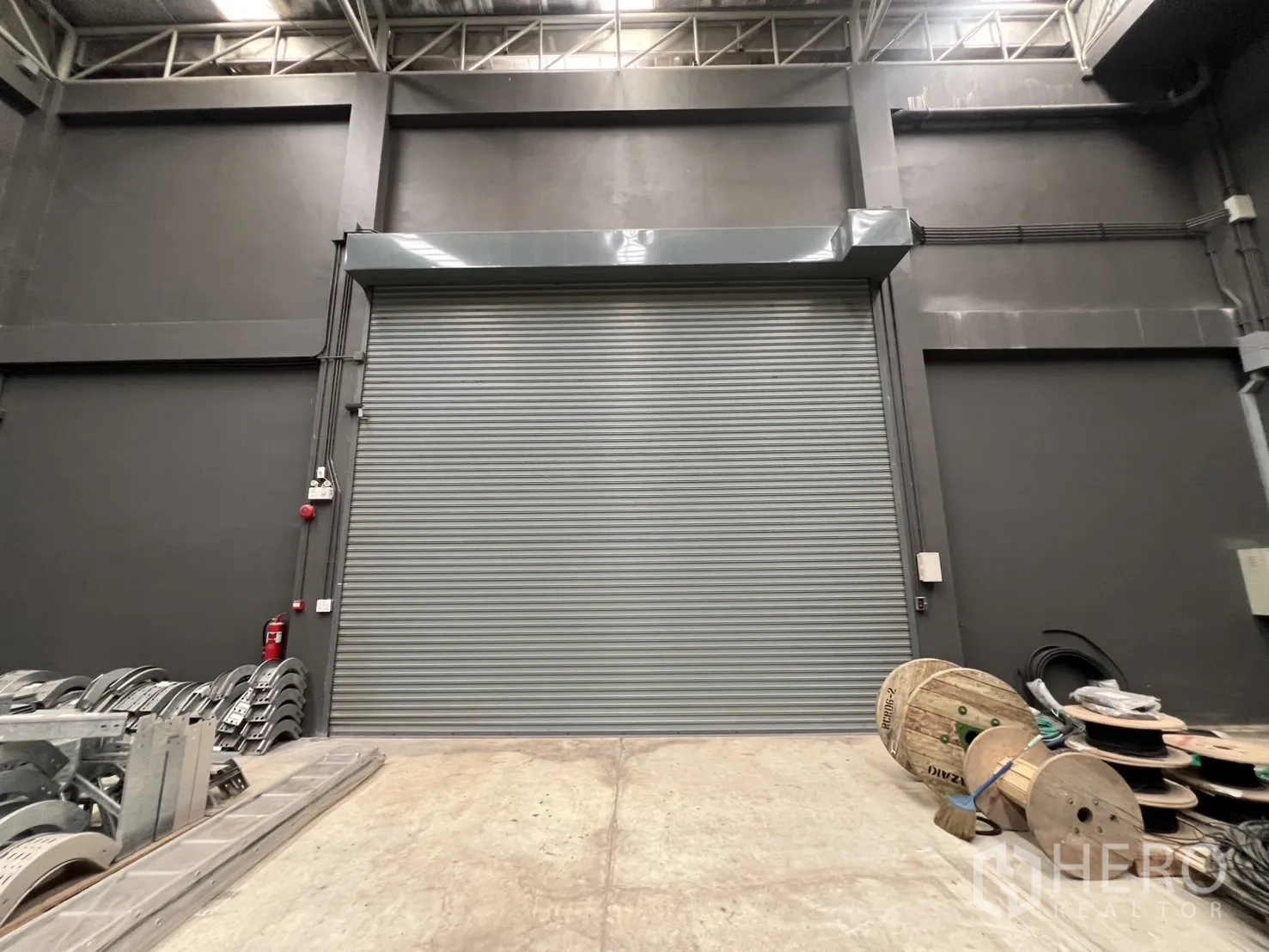 คลังสินค้า ขายในLat Krabang, Bangkok - ภาพประตูม้วนสีเทาภายในโกดังอุตสาหกรรม.