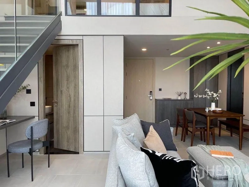 公寓 出租在Pathum Wan, Bangkok - 采光充足的起居区，入户门、高柜收纳、餐桌以及楼梯下工作台。