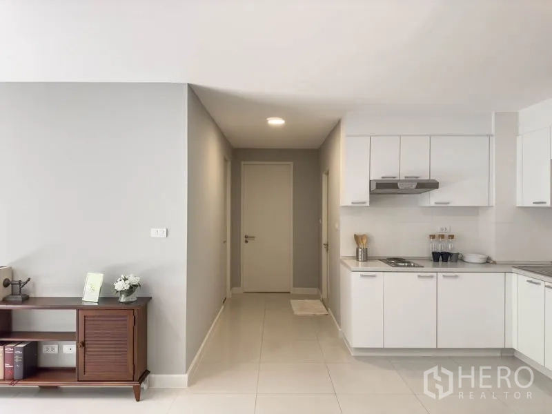 Condominium for sale in Watthana, Bangkok - Open hallway leading to a bright white built-in kitchen.