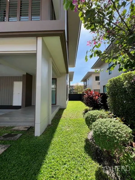 Detached House for rent in Bang Kapi, Bangkok - Private side garden with manicured lawn, shrubs and flowering tree.