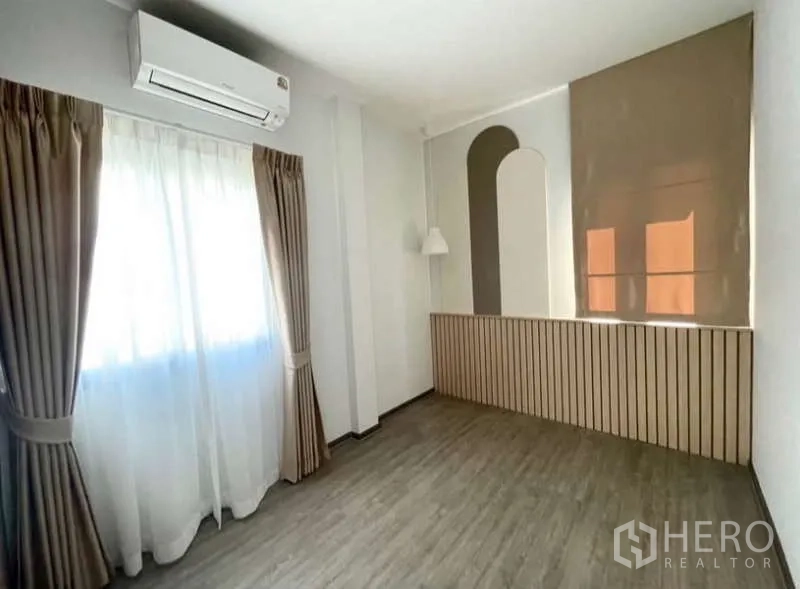 Detached House for rent in Bang Phli, Samut Prakan - Airy secondary room with wood accent wall, window and vinyl wood flooring.