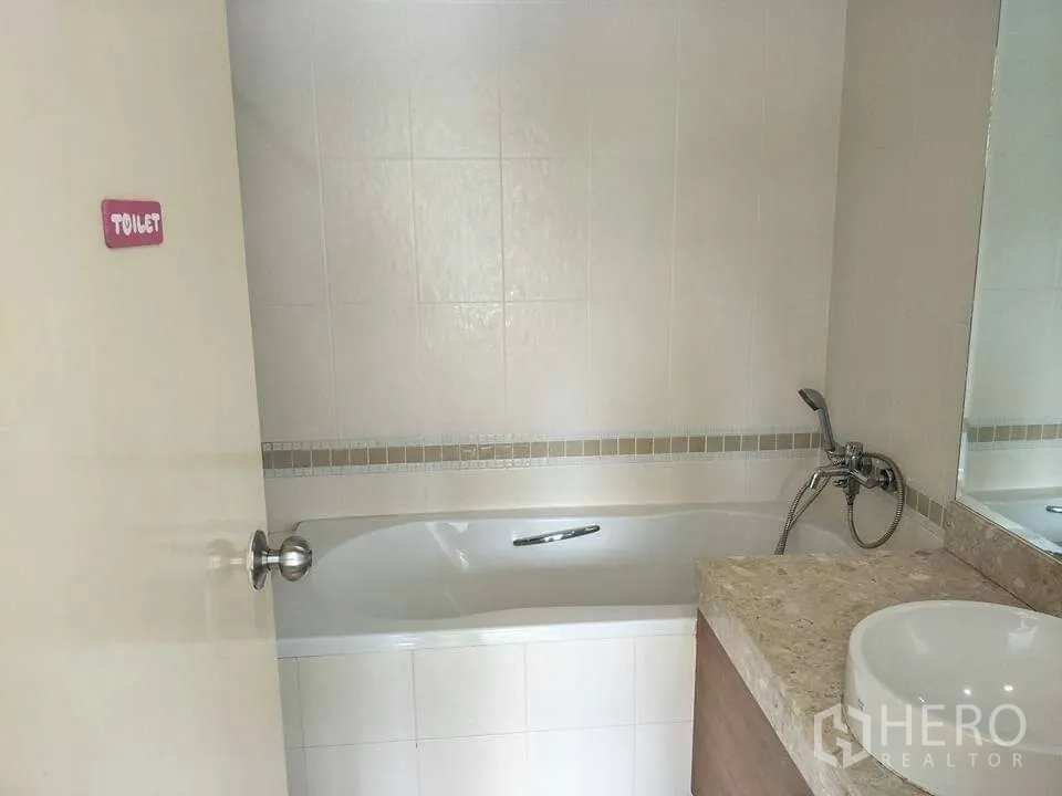 公寓 出租在Khlong Toei, Bangkok - 浴室设浴缸、手持花洒、米色石面洗手台与大镜子