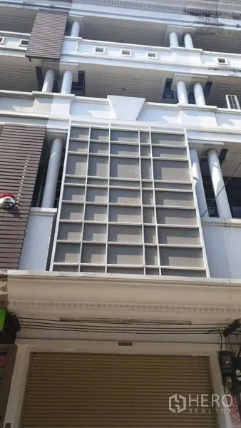 สำนักงานที่บ้าน ให้เช่าหรือขายในSuan Luang, Bangkok - ด้านหน้าอาคารทาวน์โฮมหลายชั้นพร้อมประตูม้วนชั้นล่างในกรุงเทพฯ