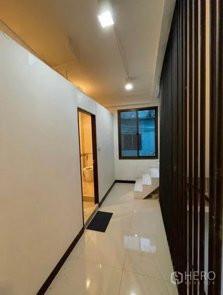 Shophouse for rent in Chatuchak, Bangkok - Hallway with window, bathroom entrance and a small stairway.