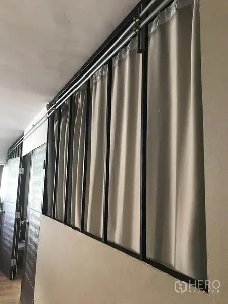 คอนโด ให้เช่าในPhaya Thai, Bangkok - โถงทางเดินพร้อมโครงเหล็กและรางเพดานแขวนผ้าม่านสีเทา ข้างประตูไม้ในคอนโดมิเนียม