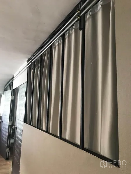 คอนโด ให้เช่าในPhaya Thai, Bangkok - โถงทางเดินพร้อมโครงเหล็กและรางเพดานแขวนผ้าม่านสีเทา ข้างประตูไม้ในคอนโดมิเนียม