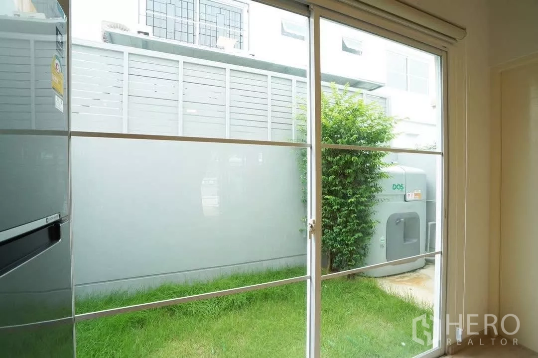 ทาวน์เฮาส์ ให้เช่าในBang Phli, Samut Prakan - มองเห็นสนามหญ้าหลังบ้านและแทงก์น้ำผ่านประตูกระจกบานเลื่อน