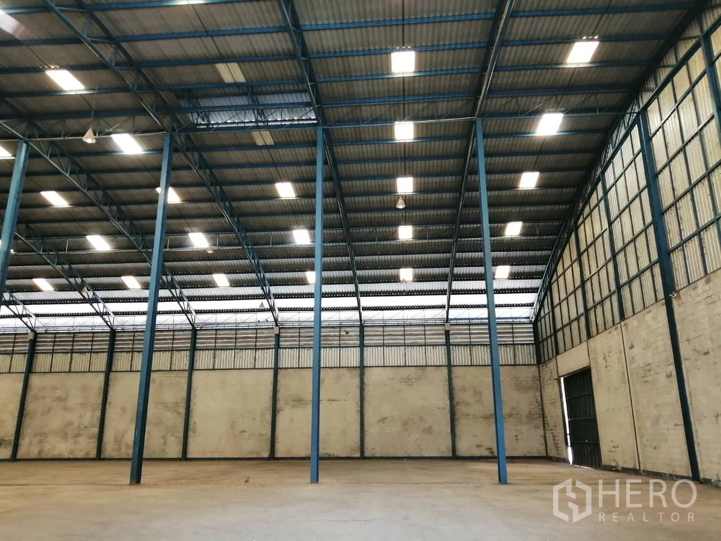 คลังสินค้า ให้เช่าในChaloem Phra Kiat, Saraburi - มุมมองภายในโกดังเพดานสูง เสาเหล็กเรียงตัว ระบบแสงสว่าง และประตูโหลดขนาดใหญ่