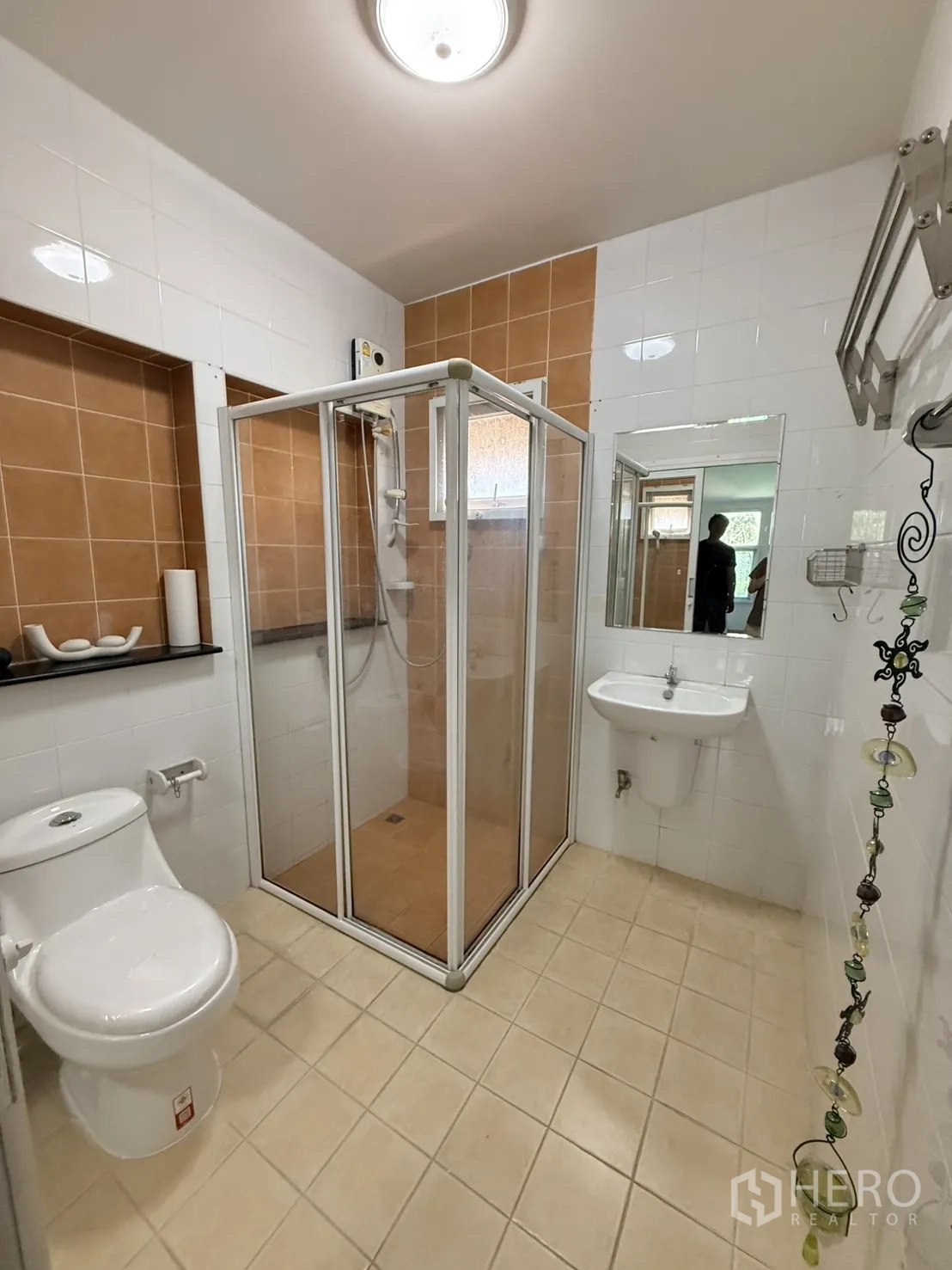 Detached House for rent in Lam Luk Ka, Pathum Thani - Bathroom with glass shower enclosure, toilet, sink, and tiled walls.