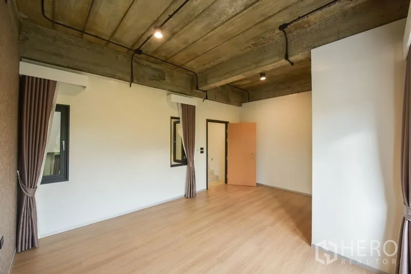 Home Office for rent or sale - Corner room with windows and curtains, featuring an exposed concrete ceiling.