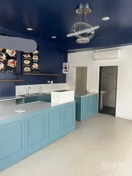 零售空间 出租在Watthana, Bangkok - 另一视角的吧台与水槽区，海军蓝天花下的嵌灯照明。