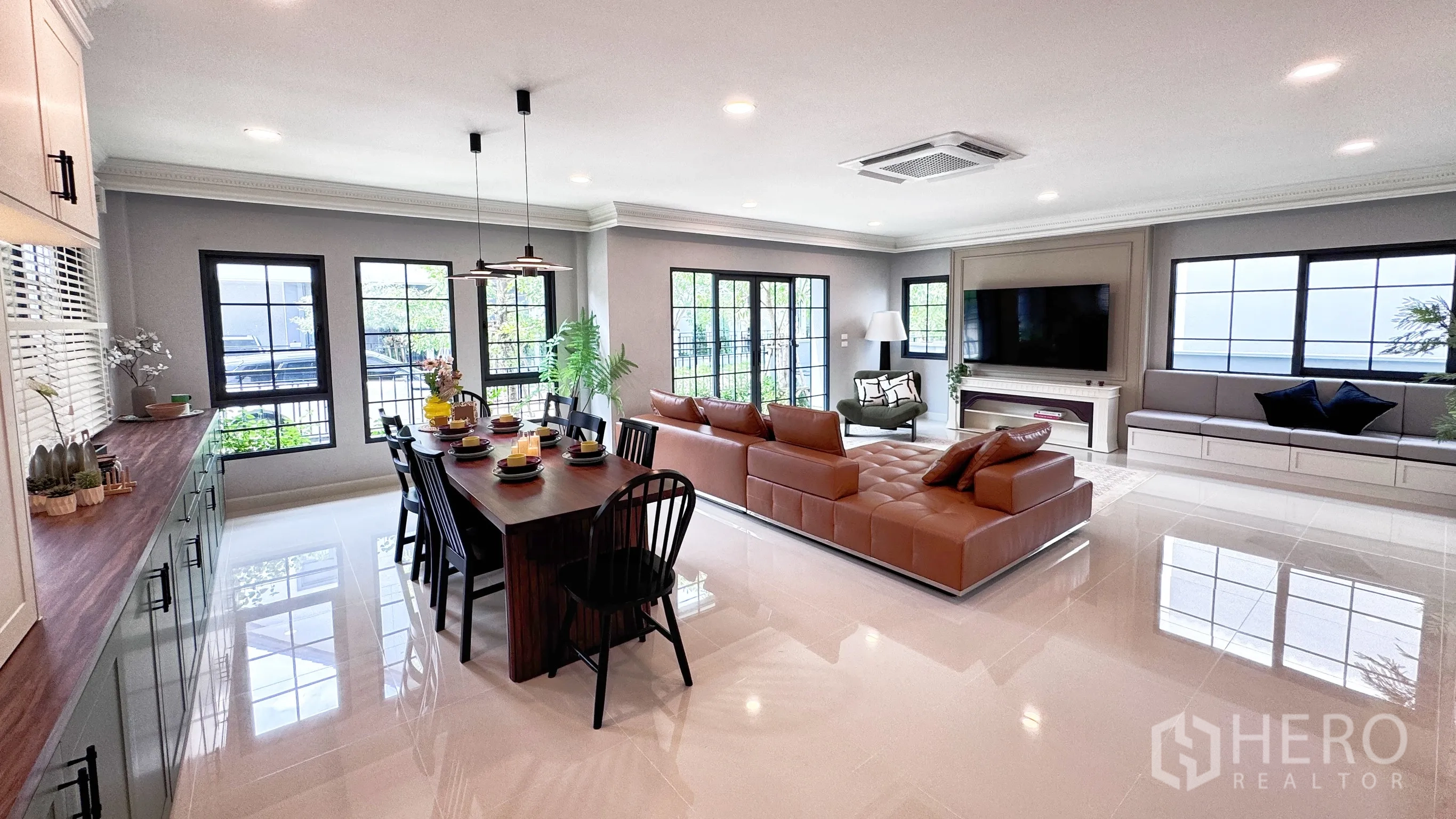 Detached House for rent in Bang Phli, Samut Prakan - Panoramic shot of open-plan room with long green lower cabinets and multiple windows.