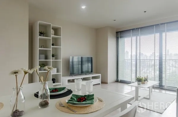 คอนโด ให้เช่าในWatthana, Bangkok - พื้นที่นั่งเล่นและทานอาหารแบบเปิดโล่ง ทีวี ชั้นวาง และประตูกระจกบานใหญ่พร้อมมู่ลี่เห็นวิวเมือง