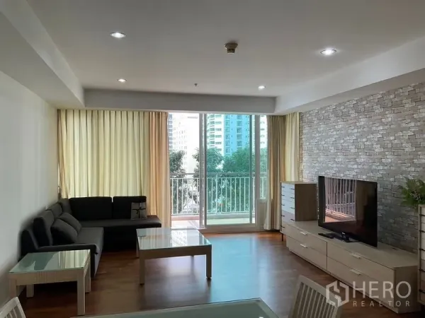 คอนโด ให้เช่าในKhlong Toei, Bangkok - ห้องนั่งเล่นสว่าง มีระเบียง โซฟา ชั้นวางทีวี และผนังลายหิน