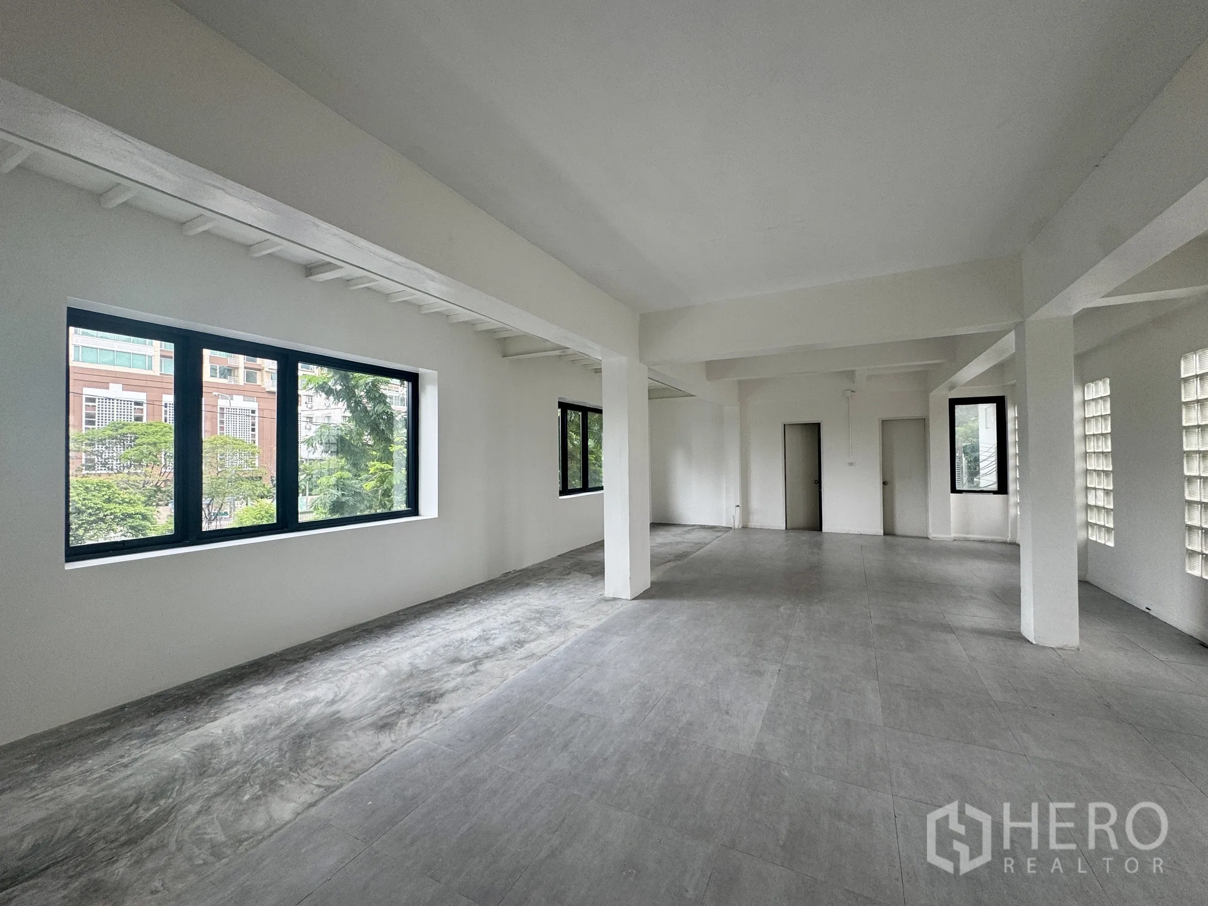 Office Space for rent in Sathon, Bangkok - Alternate view of the open-plan floor showing corner windows and light gray tiles.