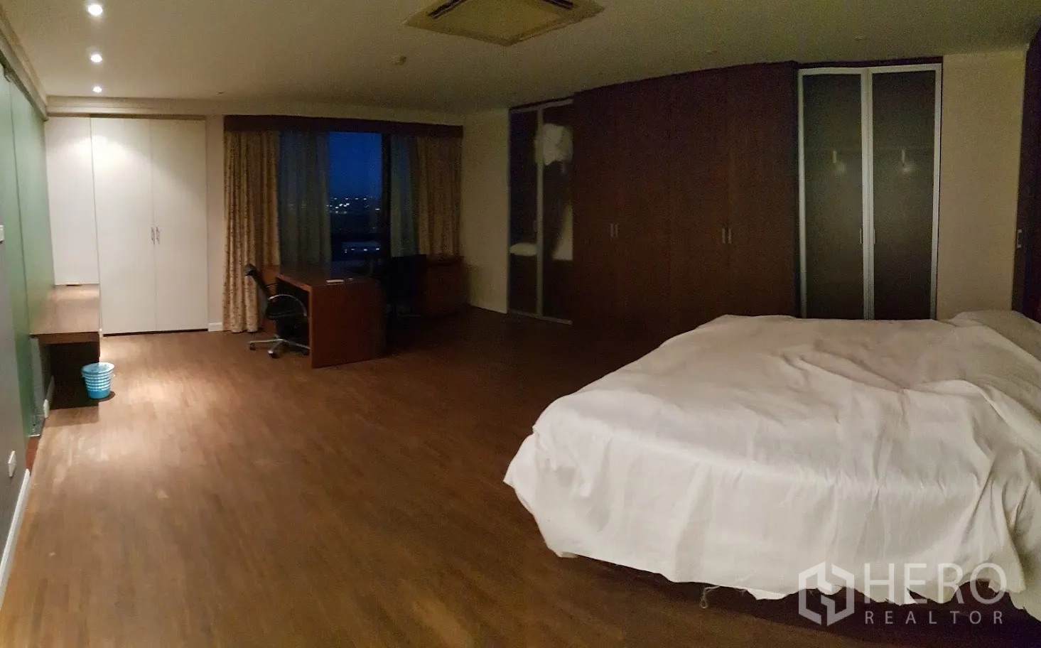 Condominium for rent in Yan Nawa, Bangkok - Bedroom with ample wardrobes, work desk and wide window, wood floors throughout.