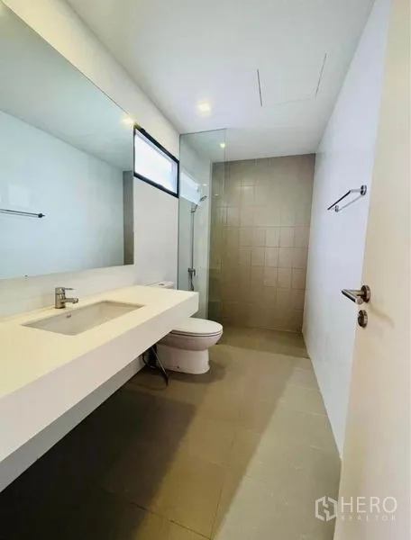 Townhouse for rent in Saphan Sung, Bangkok - Second bathroom featuring walk-in shower, extended countertop and full-width mirror.