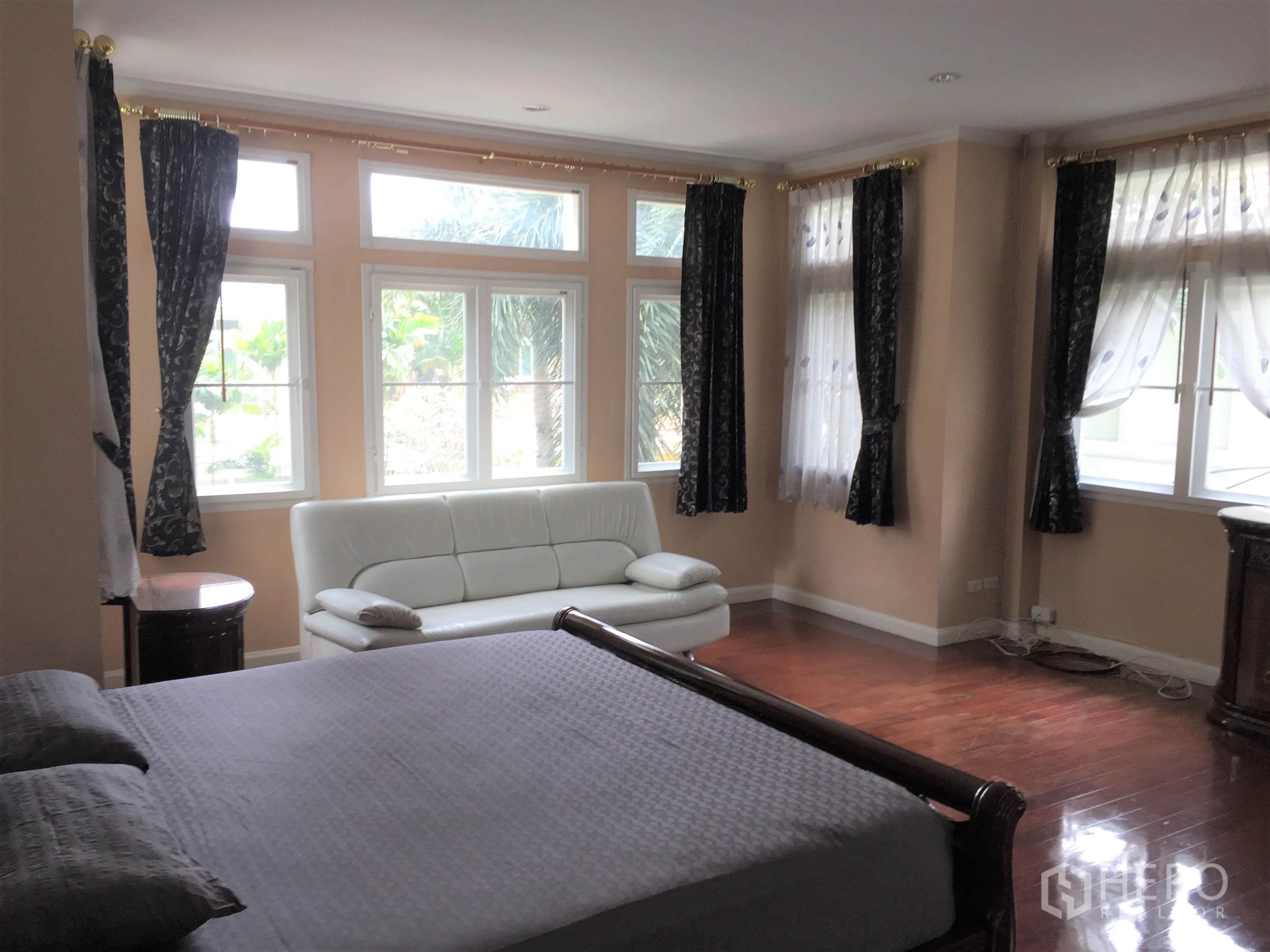 บ้าน ให้เช่าหรือขายในLat Phrao, Bangkok - ห้องนอนใหญ่พร้อมหน้าต่างมุมมองกว้าง พื้นไม้ และโซฟาสีขาว