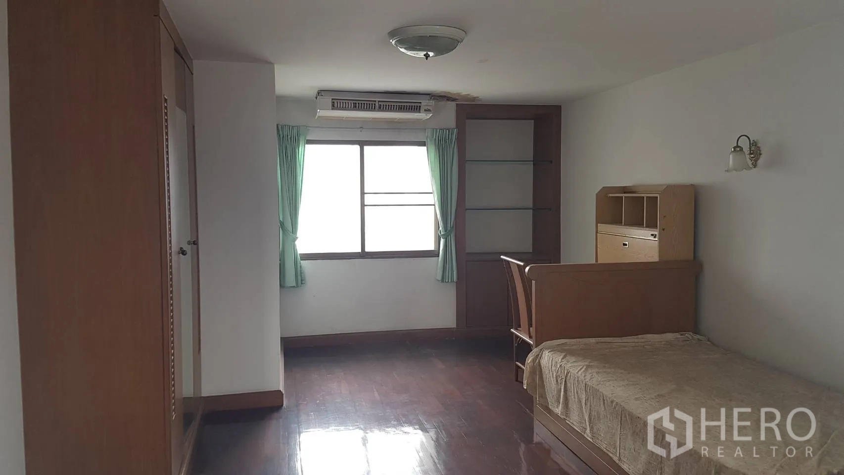 คอนโด ให้เช่าในKhlong Toei, Bangkok - ห้องนอนรองสว่าง มีเตียงเดี่ยว หน้าต่าง ผ้าม่านสีเขียว ตู้เสื้อผ้า และพื้นไม้