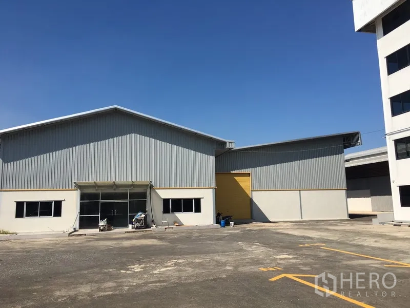 คลังสินค้า ให้เช่าในSaphan Sung, Bangkok - โกดังผนังเมทัลชีทคู่ ลานจอดกว้าง และประตูม้วนสีเหลือง