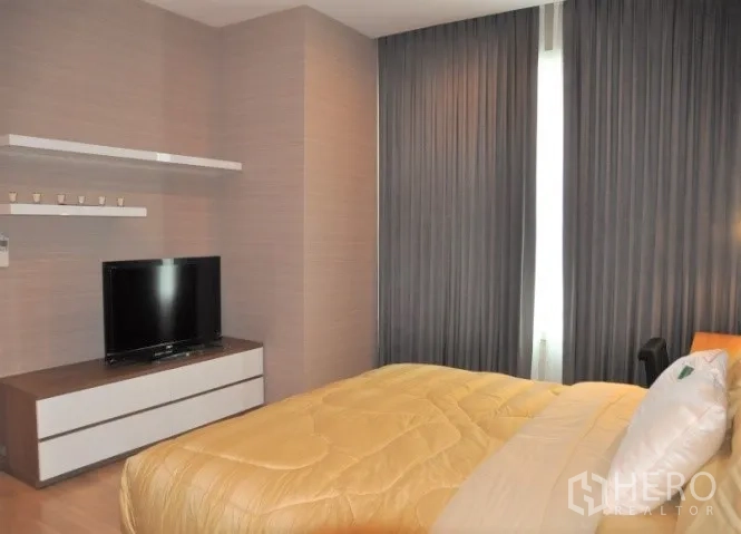 คอนโด ให้เช่าหรือขายในWatthana, Bangkok - มุมห้องนอนพร้อมชั้นวางทีวี ผ้าม่านทึบแสง และพื้นไม้