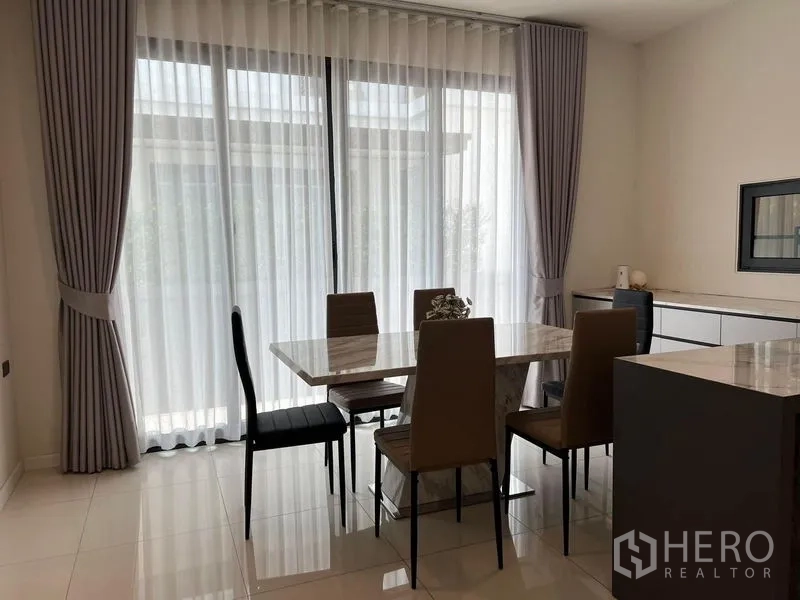 Detached House for rent or sale - Dining area with marble table beside full-height sheer curtains.