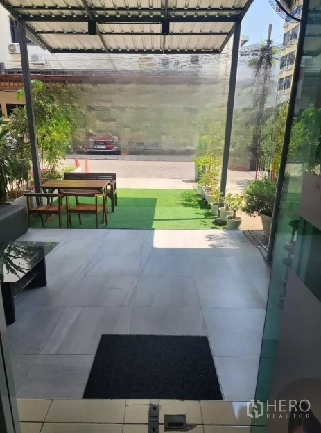 อาคารพาณิชย์ ให้เช่าในKhlong Toei, Bangkok - มุมมองจากโถงสู่เฉลียงหน้าบ้าน หลังคากันแดด สนามหญ้าเทียม และกระถางต้นไม้