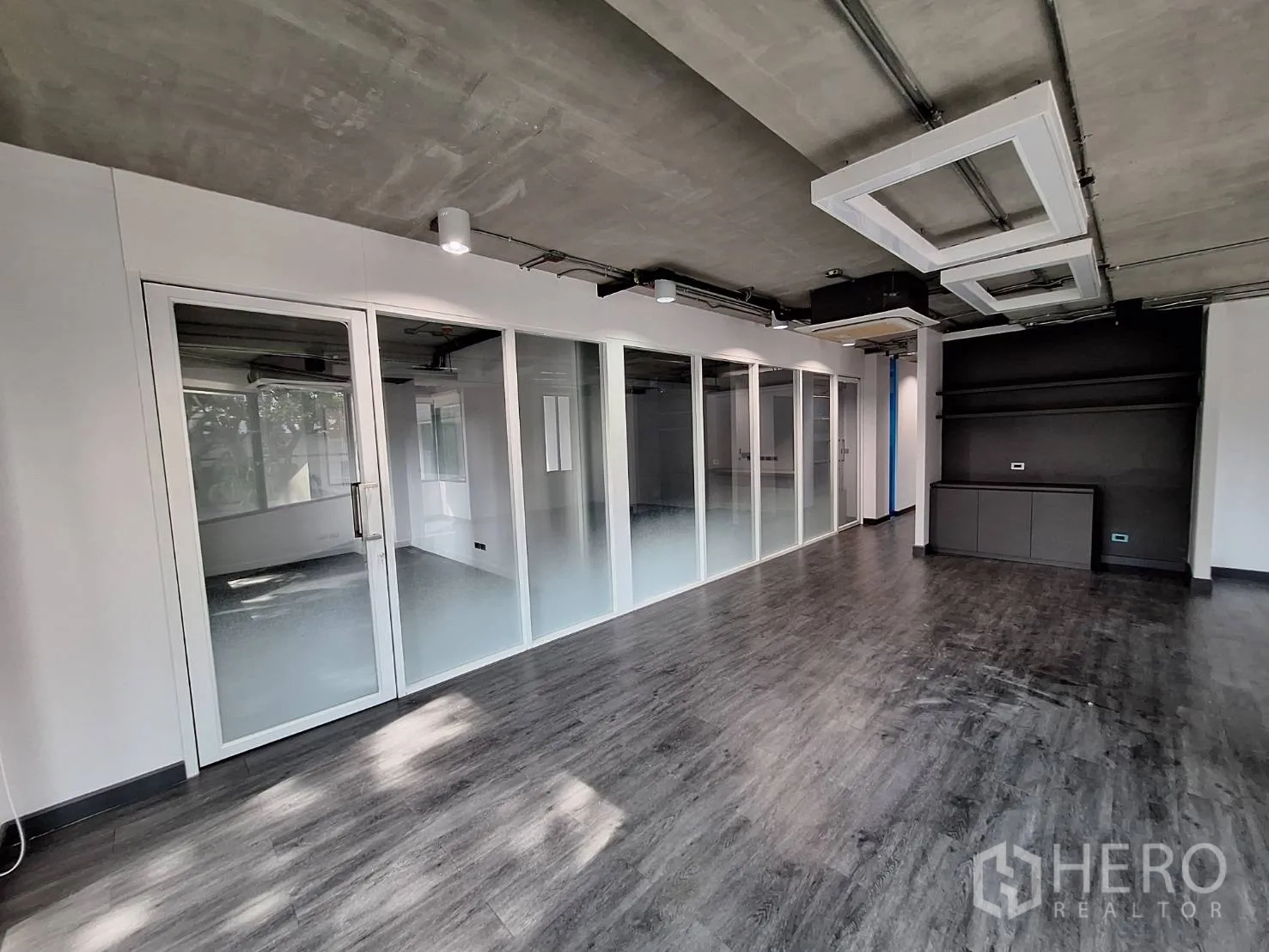 Office Space for rent - Office area with full-height frosted glass partitions and built-in shelving.