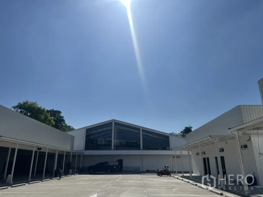 Warehouse for rent in Min Buri, Bangkok - Sunlit warehouse complex with large central yard, covered loading bays, and marked parking.