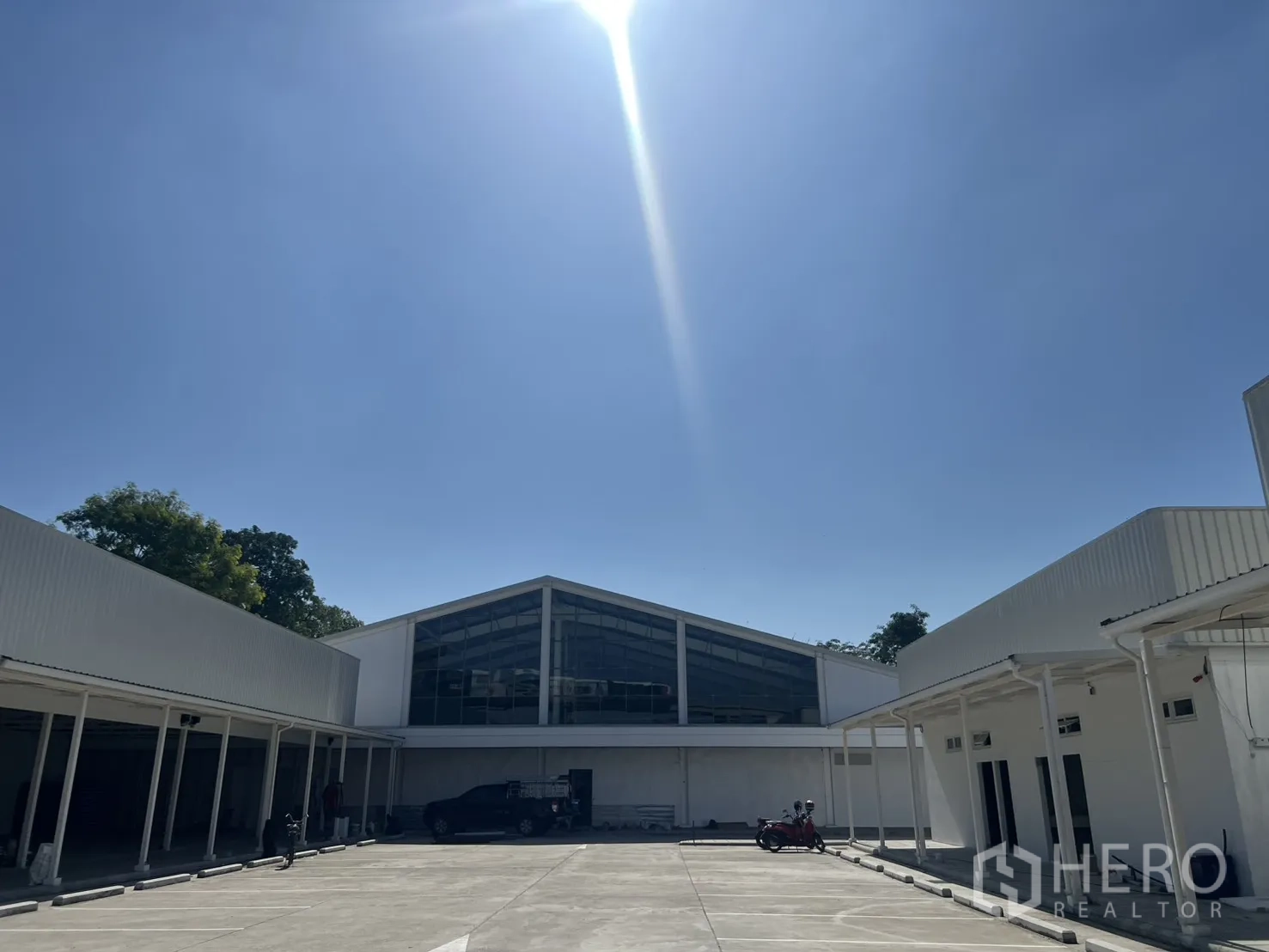 Warehouse for rent in Min Buri, Bangkok - Sunlit warehouse complex with large central yard, covered loading bays, and marked parking.