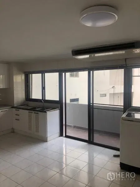 อพาร์ทเมนท์ ให้เช่าในWatthana, Bangkok - ครัวสว่างพร้อมประตูกระจกบานเลื่อนออกสู่ระเบียง มีอ่างล้างและเครื่องปรับอากาศ