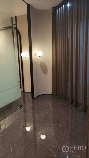 零售空间 出租 - 角落空间设落地窗帘、壁灯与高亮石材地面。