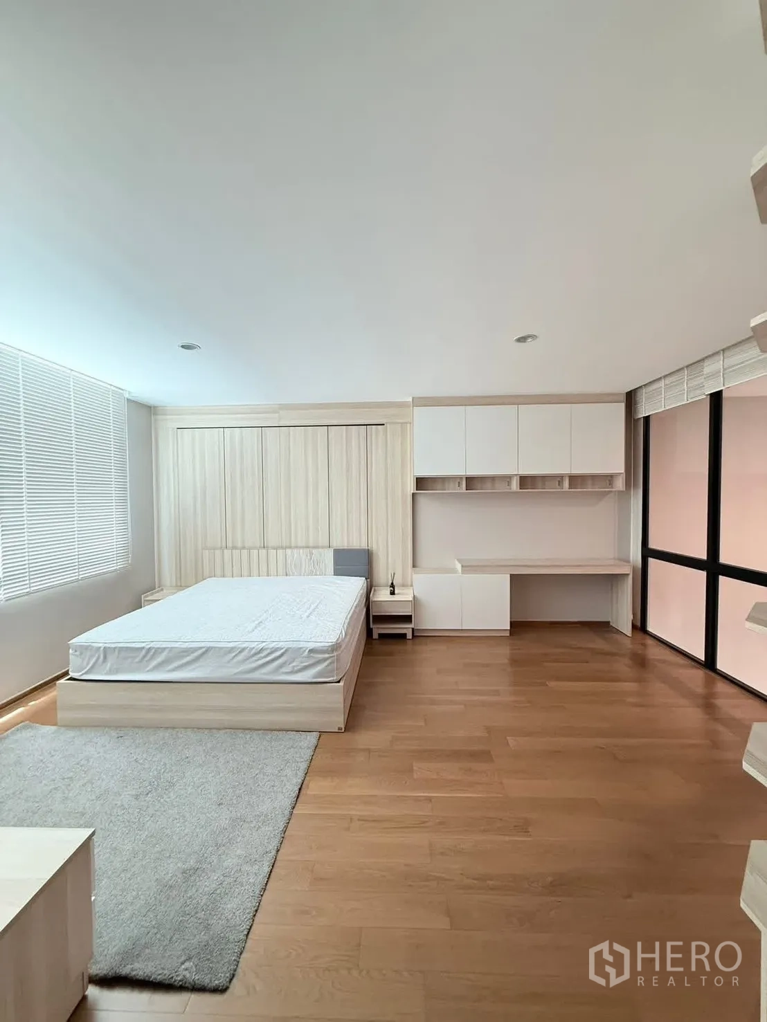 Townhouse for rent in Saphan Sung, Bangkok - Minimal bedroom with bed, desk and wide window blinds.