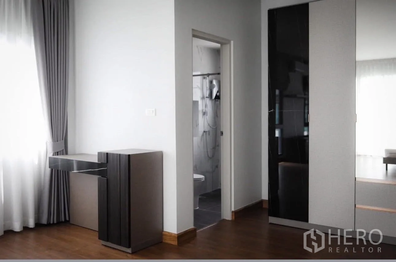 Detached House for rent in Bang Phli, Samut Prakan - Bedroom corner with console desk, doorway to an ensuite bathroom, and wardrobe.